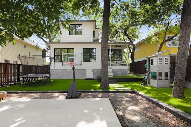 exterior space featuring a trampoline, a yard, a patio area, and a playground