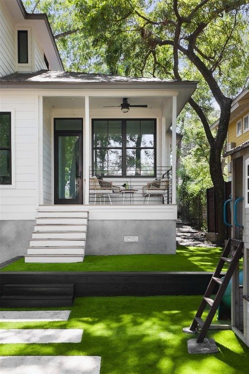 exterior space with ceiling fan, a yard, and covered porch