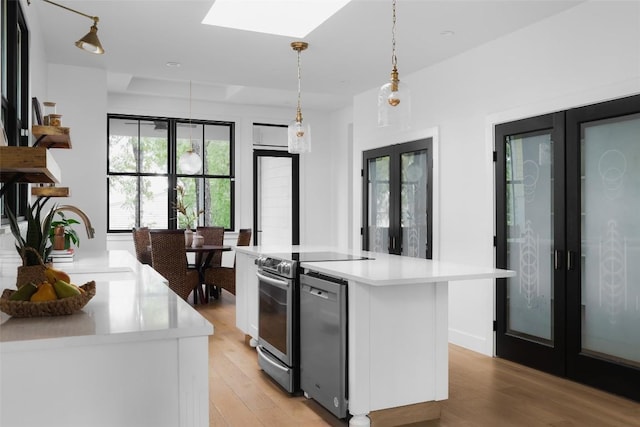 kitchen featuring stainless steel electric stove, a kitchen island, white cabinets, hanging light fixtures, and french doors