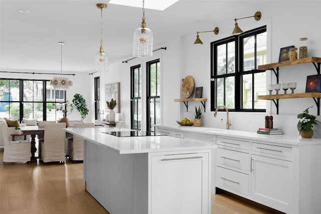 kitchen featuring white cabinetry, decorative light fixtures, black electric cooktop, and a kitchen island