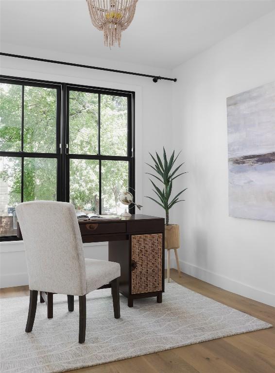 home office with an inviting chandelier and light hardwood / wood-style floors