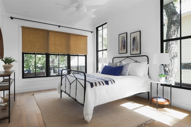 bedroom with multiple windows and light wood-type flooring