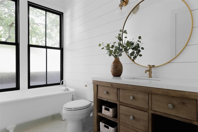 bathroom with vanity, a bath, and toilet