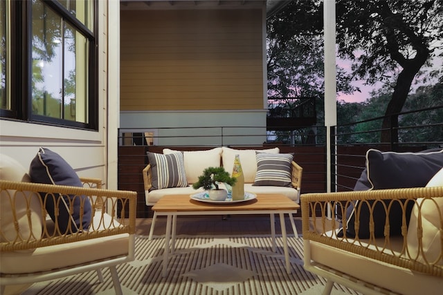 balcony at dusk featuring an outdoor living space