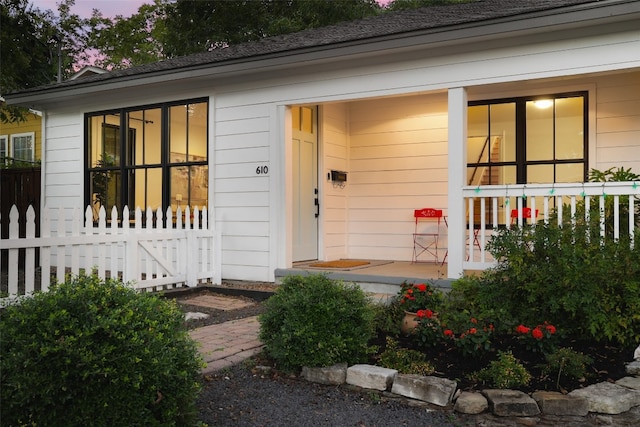 exterior entry at dusk featuring a porch