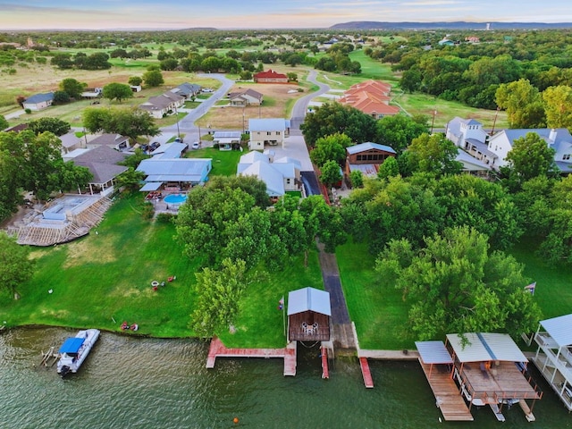 aerial view at dusk featuring a water view