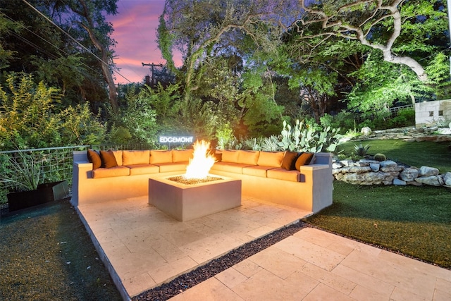 patio terrace at dusk with a yard and an outdoor living space with a fire pit