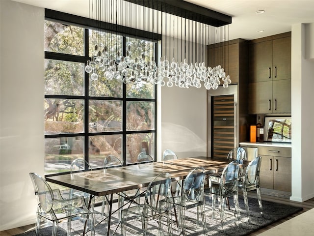 dining area with hardwood / wood-style floors, beverage cooler, and a healthy amount of sunlight