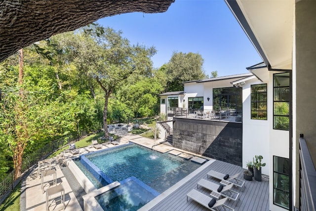 view of swimming pool featuring a wooden deck and an in ground hot tub