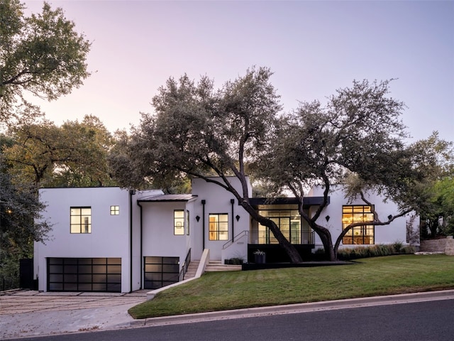 view of front of property featuring a garage and a lawn