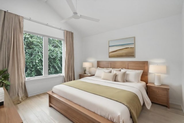 bedroom with light hardwood / wood-style flooring, vaulted ceiling, and ceiling fan