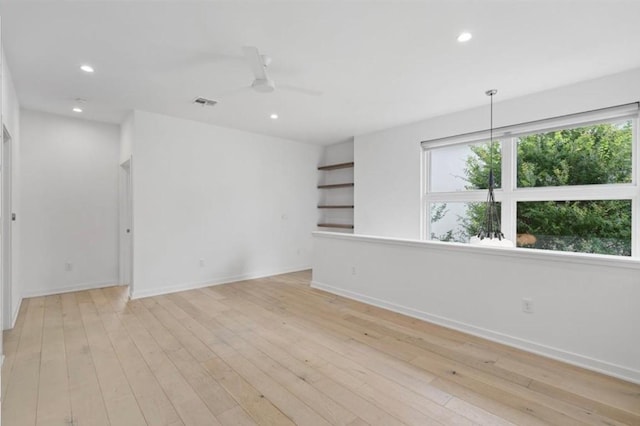 empty room featuring recessed lighting, plenty of natural light, visible vents, and light wood-style floors