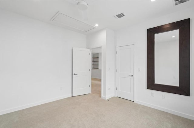 unfurnished bedroom with visible vents, light carpet, and baseboards