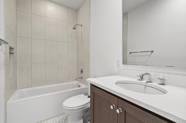 full bathroom featuring tiled shower / bath, tile patterned floors, vanity, and toilet