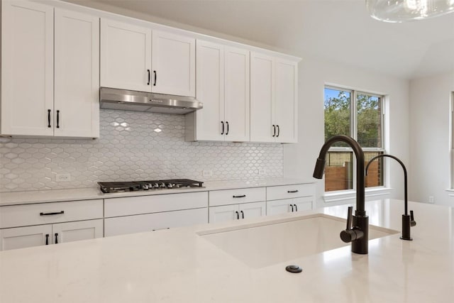 kitchen featuring white cabinets, decorative backsplash, sink, and stainless steel gas cooktop