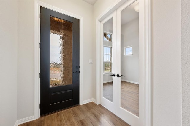 doorway with light wood-type flooring and french doors