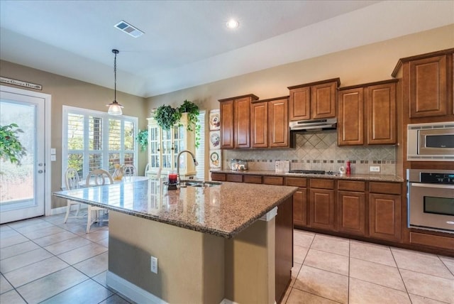 kitchen featuring a kitchen island with sink, sink, plenty of natural light, and appliances with stainless steel finishes