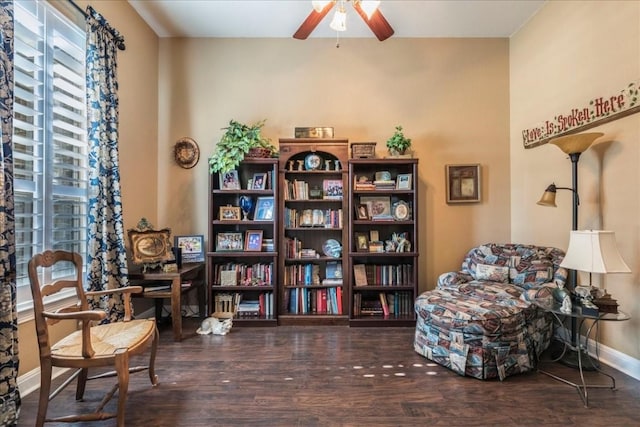 living area with ceiling fan and dark wood-type flooring