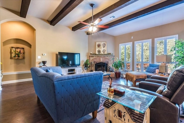 living room featuring ceiling fan, beam ceiling, dark hardwood / wood-style flooring, and a brick fireplace