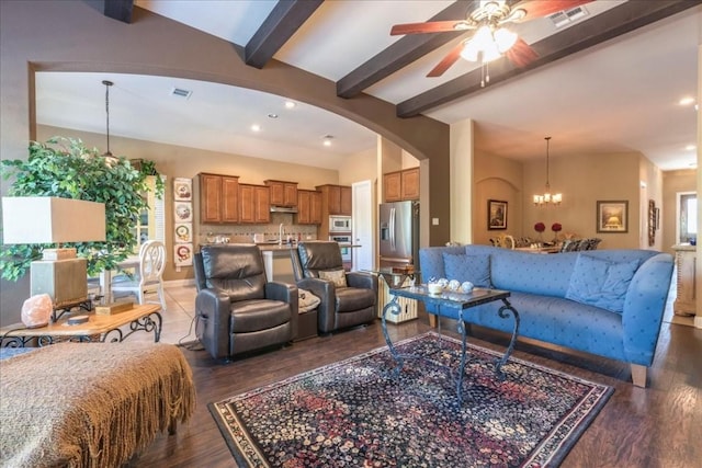 living room featuring beam ceiling, dark hardwood / wood-style flooring, ceiling fan with notable chandelier, and sink