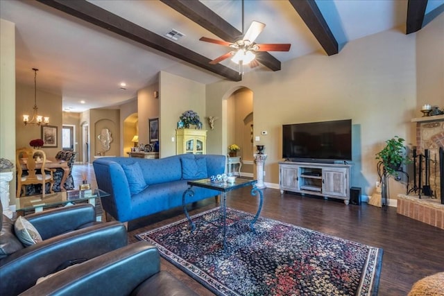 living room featuring a fireplace, beam ceiling, ceiling fan with notable chandelier, and hardwood / wood-style flooring