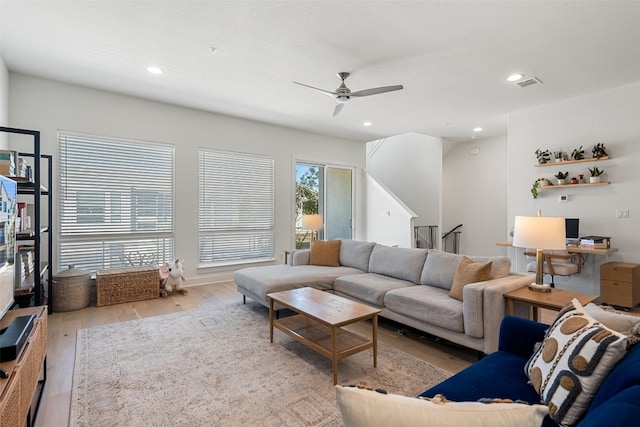 living room featuring light wood-type flooring and ceiling fan