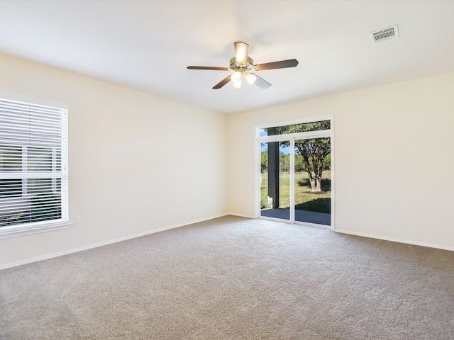 carpeted spare room featuring ceiling fan