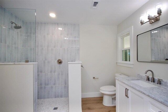 316 N Penn St, Flatonia, TX 78941 - full bathroom with a walk in shower, vanity, toilet, baseboards, and wood finished floors