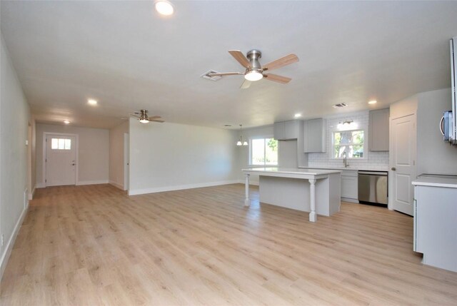 316 N Penn St, Flatonia, TX 78941 - unfurnished living room with ceiling fan, recessed lighting, light wood-style floors, a sink, and baseboards