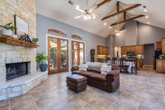 living room with ceiling fan, beamed ceiling, french doors, high vaulted ceiling, and a fireplace