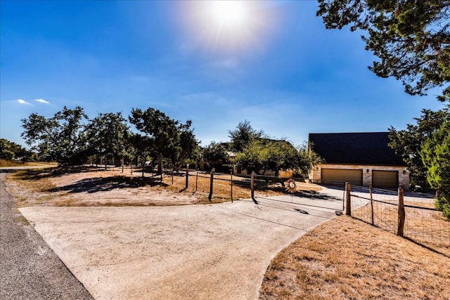 view of yard with a garage and a rural view