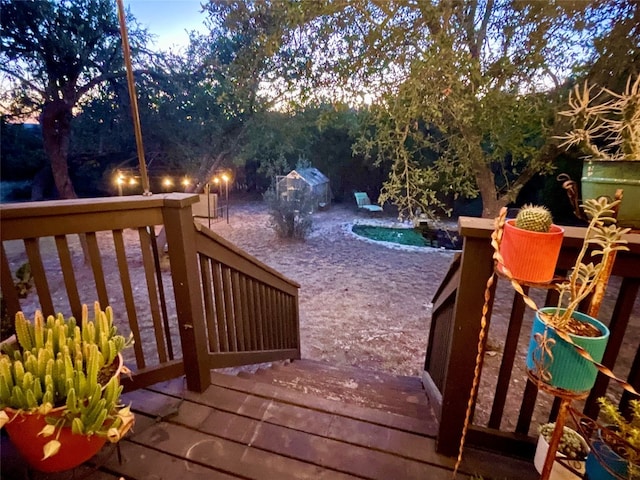 deck at dusk featuring a swimming pool