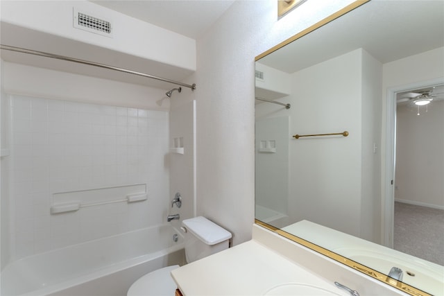 full bathroom with ceiling fan, tiled shower / bath combo, vanity, and toilet