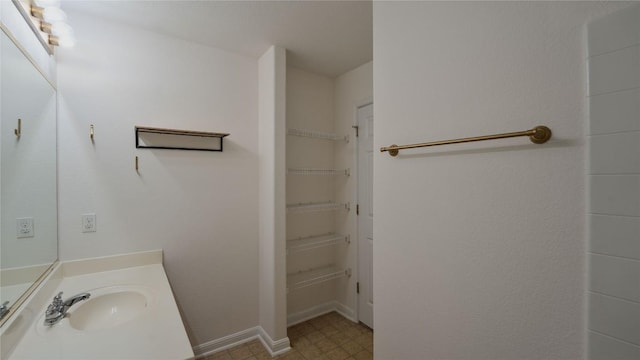 418 Shadow Pt, San Marcos, TX 78666 - bathroom featuring a spacious closet, vanity, and baseboards