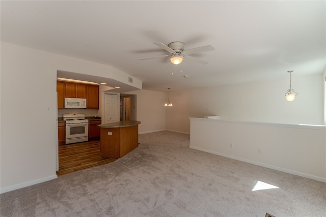 kitchen featuring ceiling fan, light colored carpet, hanging light fixtures, and white appliances