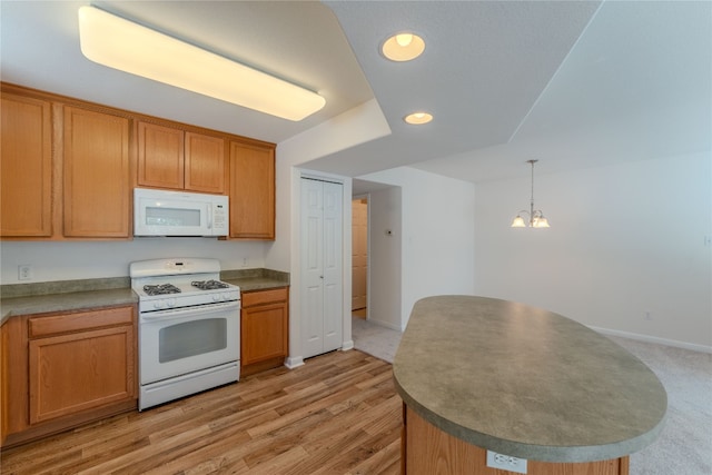 kitchen featuring hanging light fixtures, a notable chandelier, white appliances, and light hardwood / wood-style flooring