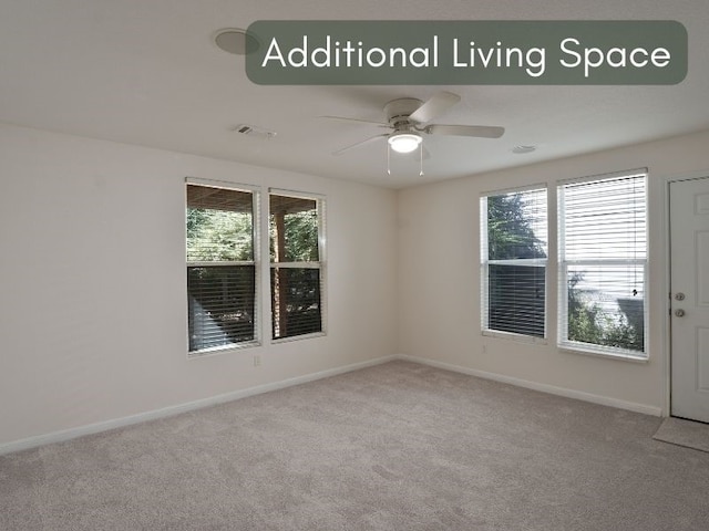 carpeted spare room with ceiling fan and a wealth of natural light