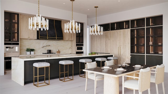 kitchen featuring backsplash, light hardwood / wood-style floors, stainless steel oven, and sink