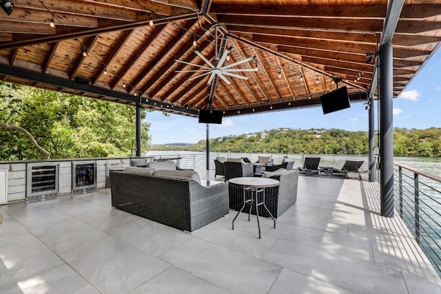 view of patio featuring a gazebo, ceiling fan, wine cooler, and an outdoor hangout area