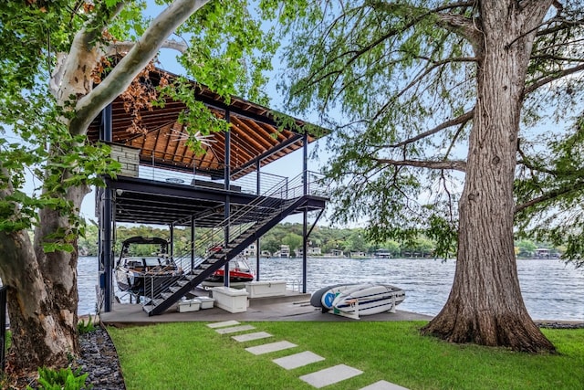 view of dock with a lawn and a water view