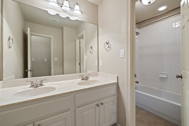 bathroom with tiled shower / bath combo, vanity, and tile patterned floors