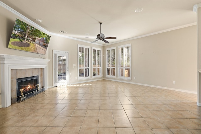 unfurnished living room with light tile patterned floors, ornamental molding, a tiled fireplace, and ceiling fan