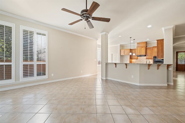 unfurnished living room with light tile patterned floors, crown molding, and decorative columns