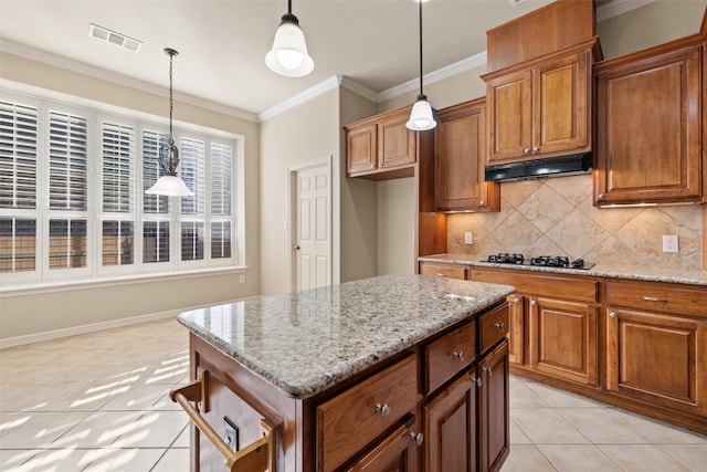 kitchen featuring gas cooktop, a center island, light tile patterned floors, and light stone counters