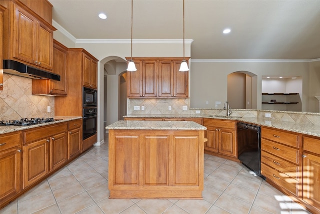 kitchen featuring hanging light fixtures, light stone counters, a kitchen island, black appliances, and sink