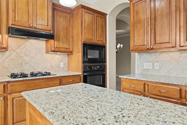 kitchen with ventilation hood, black appliances, decorative backsplash, and light stone countertops