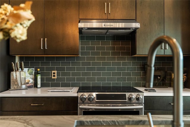 kitchen with stainless steel range oven, extractor fan, and tasteful backsplash