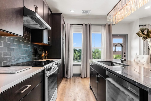 kitchen with sink, light hardwood / wood-style flooring, decorative backsplash, appliances with stainless steel finishes, and range hood