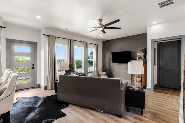 living room with light wood-type flooring and ceiling fan