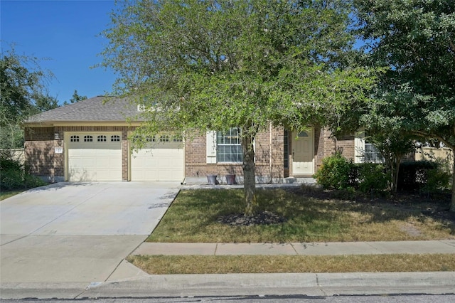 13108 Craven Ln, Manor, TX 78653 - view of property hidden behind natural elements featuring a garage, brick siding, concrete driveway, and a front yard